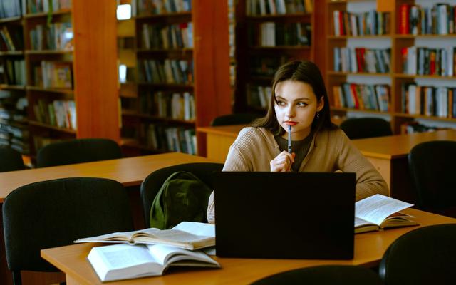 eine-frau-die-an-einem-tisch-vor-einem-laptop-sitzt