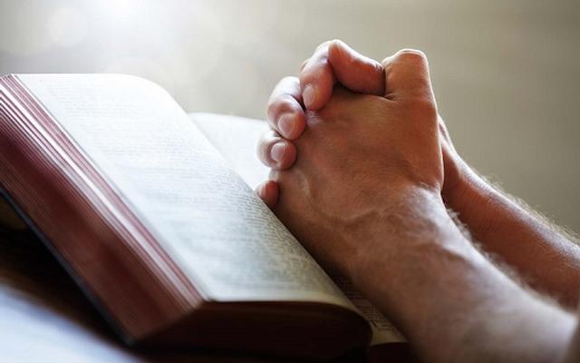 betende Hände auf Bibel