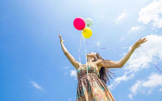 Frau lässt Ballone fliegen