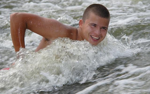 Junger Mann schwimmt gegen den Strom.