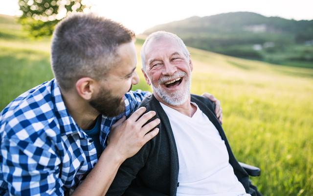 Zufriedener Mann im Rollstuhl mit seinem Sohn
