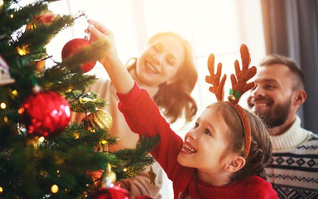 Familie schmückt einen Weihnachtsbaum