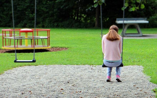 Mädchen alleine auf dem Spielplatz