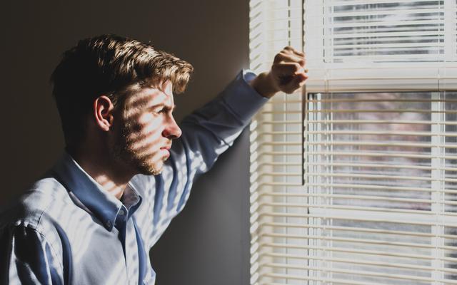 Mann blickt aus dem Fenster