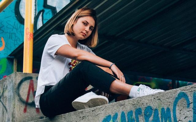 Jugendliche sitzt auf einer Mauer