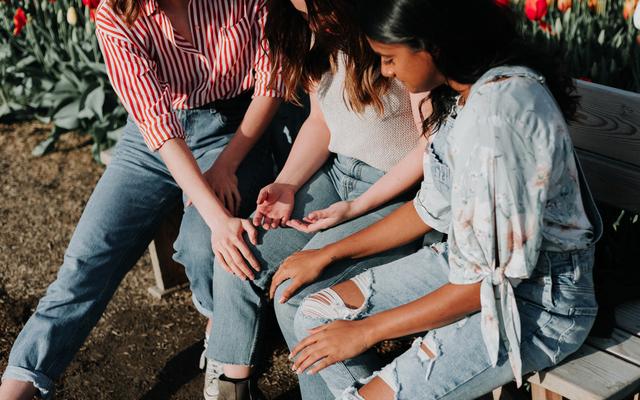 Drei junge Frauen beten miteinander