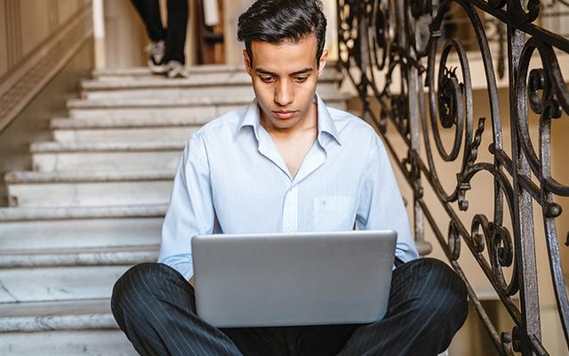 Junger Mann aus dem Nahen Osten vor einem Computer