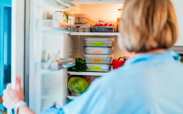 Eine Frau vor dem vollen Kühlschrank