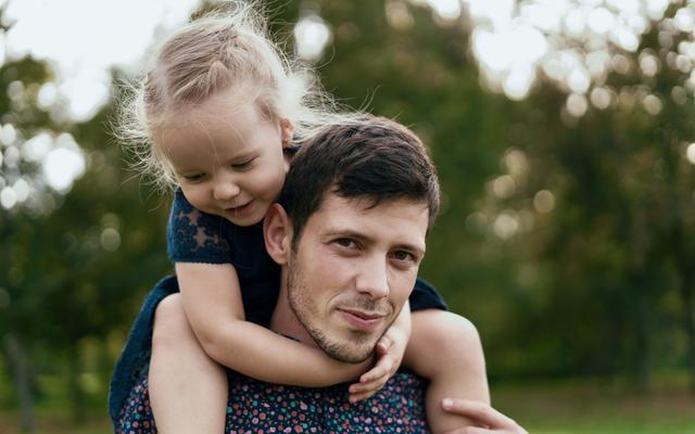 Ein Vater mit seiner kleinen Tochter auf den Schultern