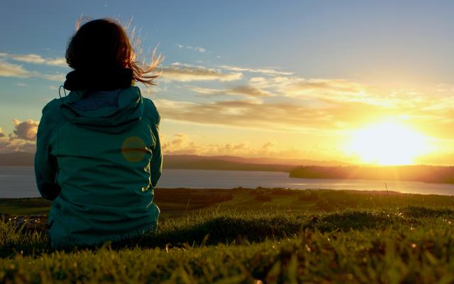 Eine Frau geniesst den Sonnenaufgang