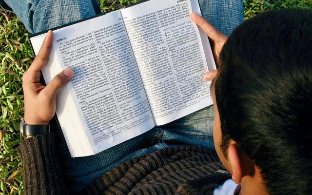 Junger Mann liest die Bibel