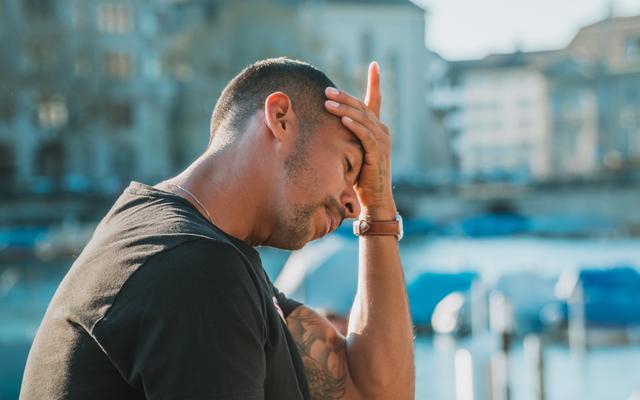 Mann fasst sich verzweifelt an den Kopf