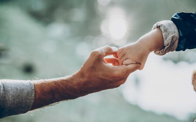 Ein Vater reicht seinem Sohn die Hand