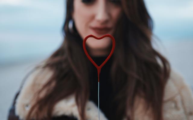 Frau mit rotem Herz in den Händen