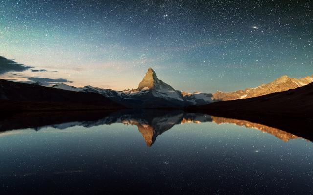 Das Matterhorn bei Nacht - umringt von Sternen.