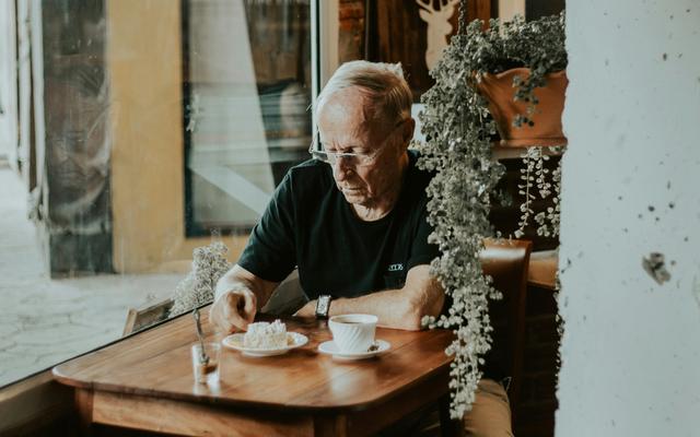 Senior alleine im Café