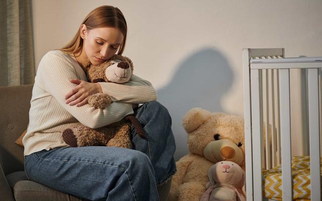 Frau im Kinderzimmer ohne ein Kind