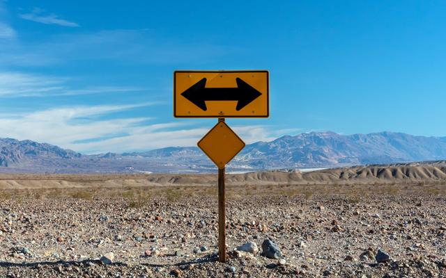 Ein Strassenschild, das in gegensätzliche Richtungen zeigt.