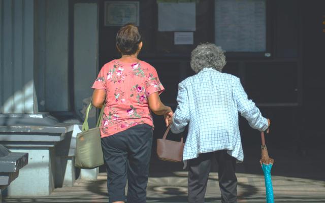 person-hilft-alter-frau-über-strasse