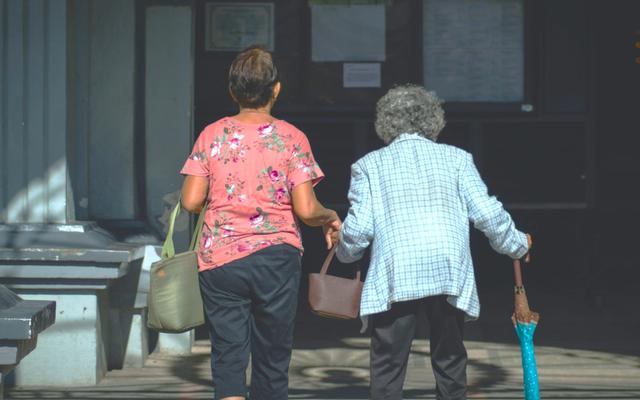person-hilft-alter-frau-über-strasse