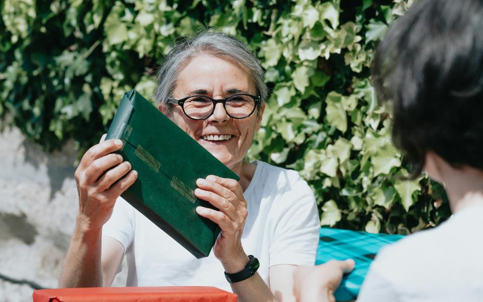eine-frau-die-eine-geschenk-vor-einer-frau-halt