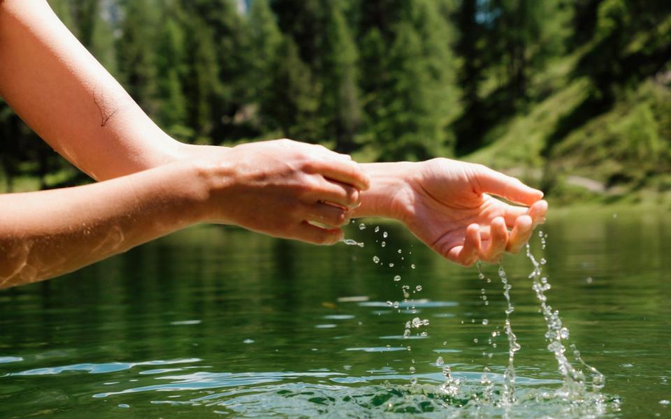 Hände kühlen sich im Fluss