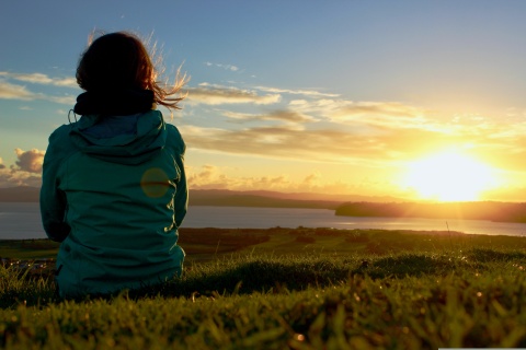 Eine Frau geniesst den Sonnenaufgang