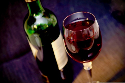 Ein Glas Wein mit der Flasche nebendran