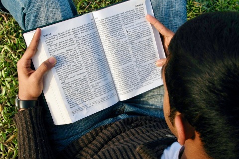 Junger Mann liest die Bibel