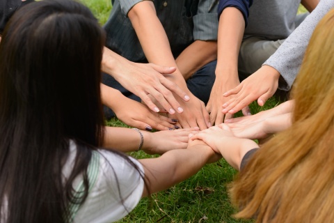 Viele Hände treffen sich in der Mitte