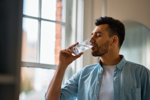 Durstiger Mann trinkt ein Glas Wasser