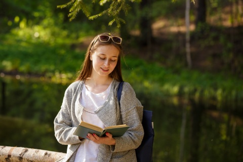 Frau liest in einem Buch (Symbolbild)