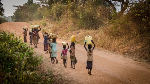 Kinder transportieren Wasser in Uganda