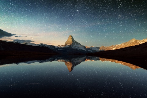 Das Matterhorn bei Nacht - umringt von Sternen.