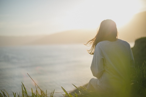 Junge Frau sieht aufs Meer hinaus