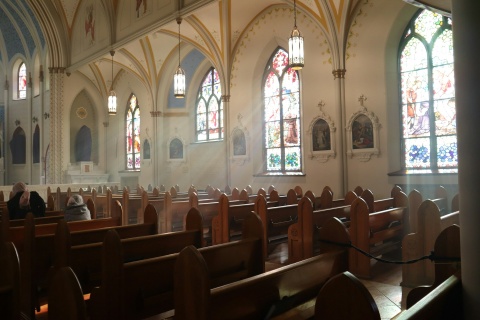 Nur wenige Menschen sitzen auf den Bänken dieser Kirche.