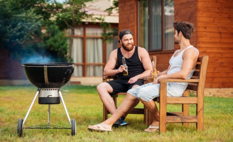 Zwei Männer pflegen die Freundschaft beim Grillieren.
