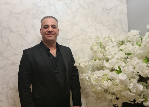 Ayad Potros neben dem Strauss weisser Blumen