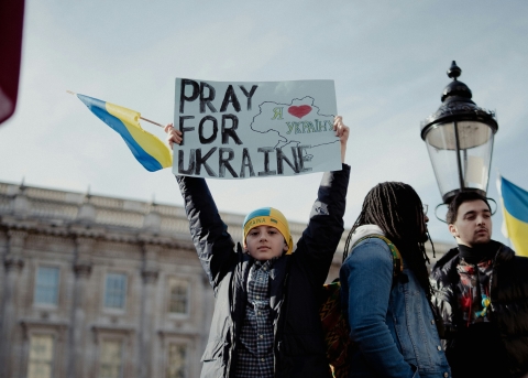 Ein Kind hält ein Plakat mit der Aufschrift «Pray for Ukraine» 