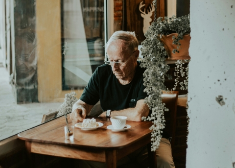 Senior alleine im Café