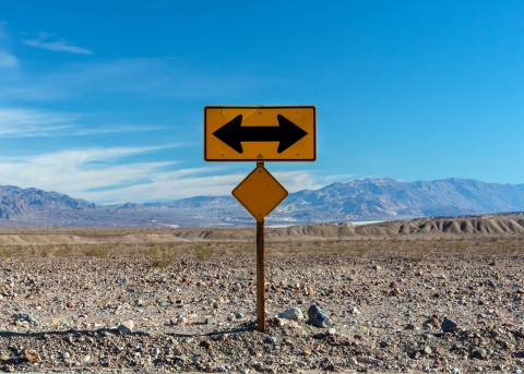 Ein Strassenschild, das in gegensätzliche Richtungen zeigt.