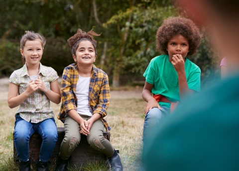 Kinder hören ihrem Leiter bei einem Input zu (Symbolbild)